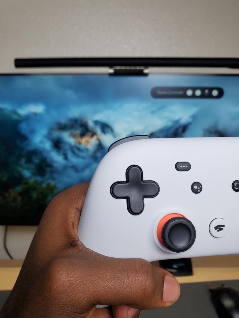 A controller held in front of a screen.