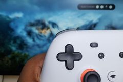 A controller held in front of a screen.